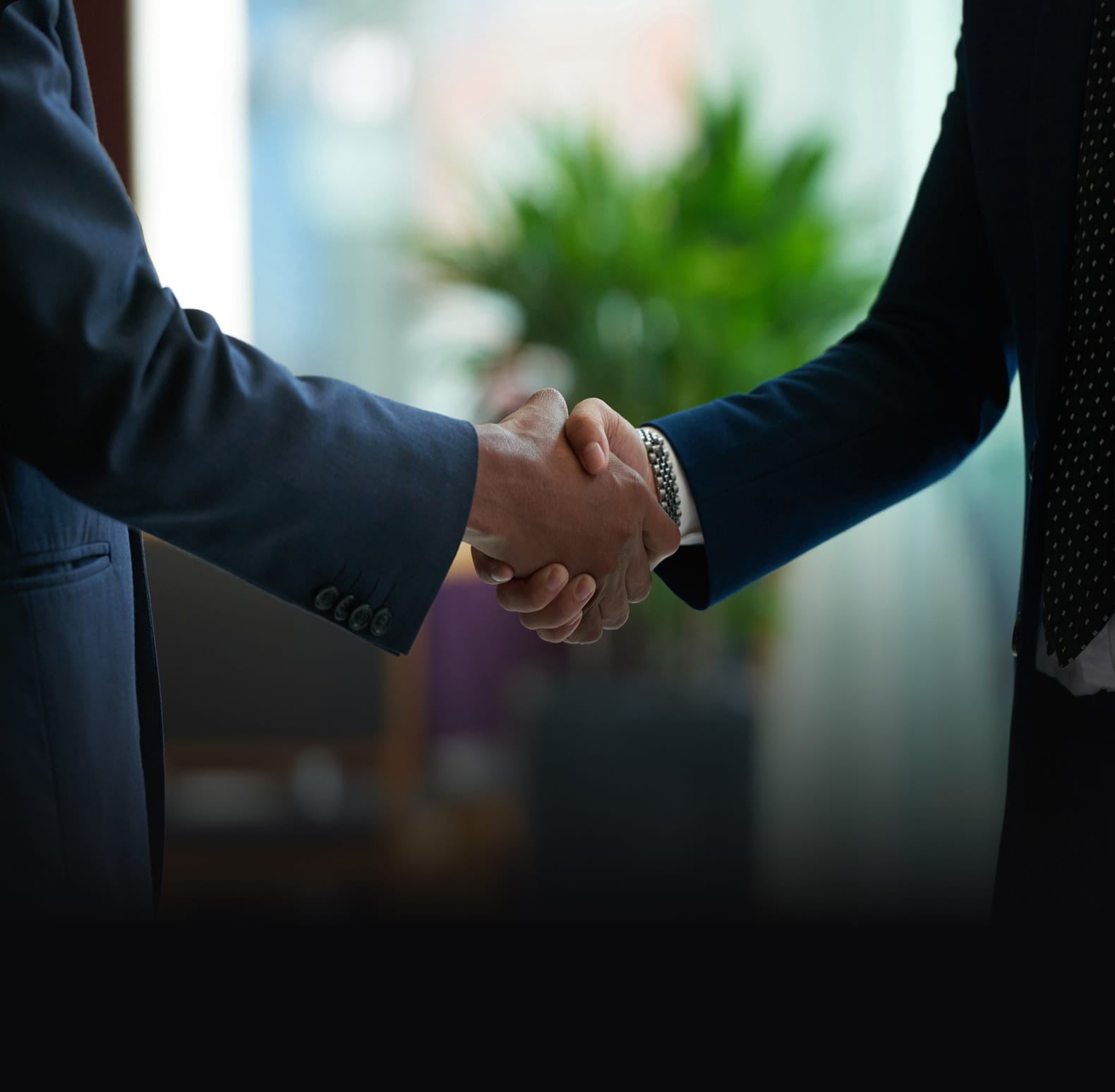 A close-up of two business professionals shaking hands, symbolizing a finalized distributor partnership.